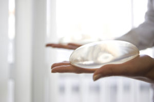 doctor holding silicone breast implant