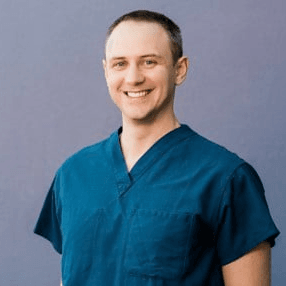 Profile picture of Dr. VanderWel wearing scrubs in front of blue background
